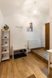 uma sala de estar com paredes brancas e pisos em madeira em Red Fountain Studio em Braşov