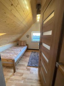 Habitación en el ático con cama y puerta en Domek w Polu, en Burbiski