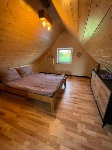 1 dormitorio grande con 1 cama en el ático en Domek w Polu, en Burbiski