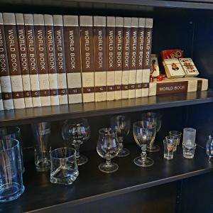 un estante con copas de vino y libros. en Station House, en Pagani