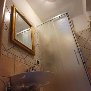 uma casa de banho com um lavatório e um chuveiro com um espelho. em Station House em Pagani