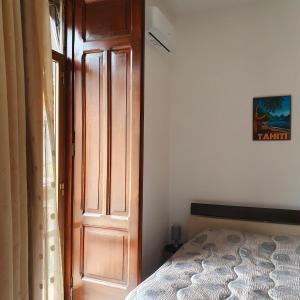 um quarto com uma cama ao lado de uma porta de madeira em Station House em Pagani