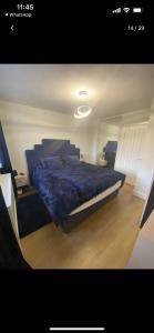 um quarto com uma cama com um edredão azul em Beautiful 3 Bedroom Detached home with hot tub em Fisherrow