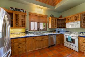 a kitchen with wooden cabinets and white appliances at Casa Patricia in Loreto