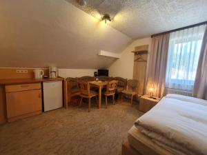 ein Hotelzimmer mit einem Bett, einem Tisch und Stühlen in der Unterkunft Café Pension Sonnenkanzel in Staatsbad Brückenau