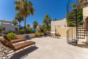 a patio with benches and palm trees at Casa Patricia in Loreto