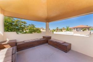 an outdoor patio with cushioned furniture and a large window at Casa Patricia in Loreto