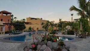 a resort with a swimming pool with tables and chairs at Casa Patricia in Loreto