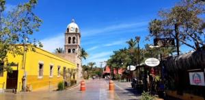 a building with a clock tower in the middle of a street at Casa Patricia in Loreto