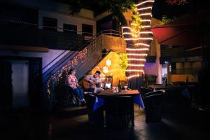 dos personas sentadas en mesas en un restaurante por la noche en Casa Patricia, en Loreto