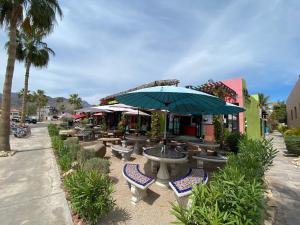 a group of tables and chairs with an umbrella at Casa Patricia in Loreto