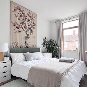 a bedroom with a bed and a painting on the wall at Beautiful Private Room in Levenshulme in Manchester