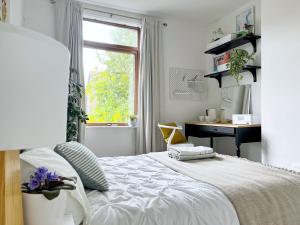 a bedroom with a bed with a desk and a window at Beautiful Private Room in Levenshulme in Manchester