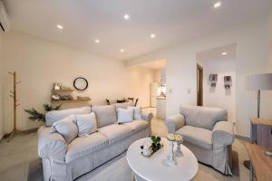 ein Wohnzimmer mit einer Couch und zwei Stühlen und einem Tisch in der Unterkunft Alfa home in Iraklio