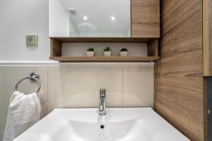 ein Badezimmer mit einem Waschbecken und zwei Topfpflanzen in der Unterkunft Alfa home in Iraklio + 57 Fotos