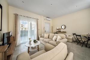 ein Wohnzimmer mit Sofa und Tisch in der Unterkunft Alfa home in Iraklio