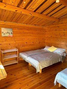 a bedroom with a bed in a wooden cabin at Karjamaa Garden Bungalows in Pärnu