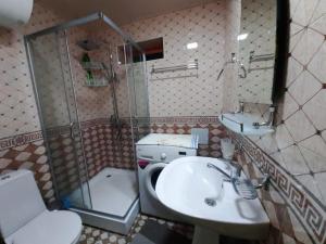 uma casa de banho com um lavatório, um chuveiro e um WC. em Place to stay em Samarkand