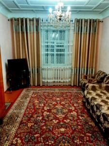 uma sala de estar com um sofá e um tapete grande em Place to stay em Samarkand