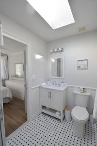 La salle de bains blanche est pourvue de toilettes et d'un lavabo. dans l'établissement Private Summer Rental Beach House with a 30ft Boat Dock, à Southampton