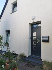 a black door on the side of a white house at Ferienwohnung Lojane in Kranenburg