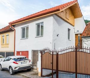 une maison blanche avec une voiture garée devant elle dans l'établissement Red Fountain Studio, à Braşov