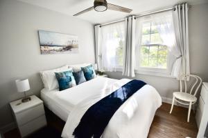 サウサンプトンにあるPrivate Summer Rental Beach House with a 30ft Boat Dockのベッドルーム(青い枕の大きな白いベッド付)