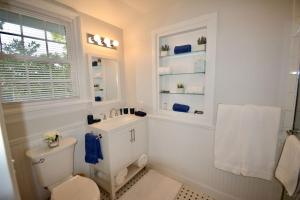 a bathroom with a toilet and a sink and a window at Private Summer Rental Beach House with a 30ft Boat Dock in Southampton