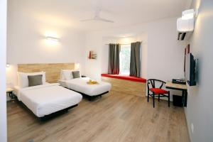 Habitación de hotel con 2 camas, escritorio y silla en OYO Townhouse 17 Huda City Center Near Leisure Valley Park en Gurgaon