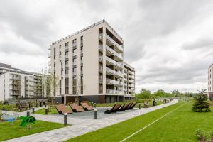 a large white building with benches in a park at Praga Residence Premium in Warsaw