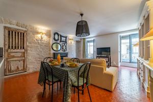 a living room with a table and a couch at L'envoutement provençal au cœur de l'écusson - Une Nuit à Nîmes in Nîmes