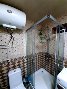 uma cabina de duche em vidro numa casa de banho com WC em Place to stay em Samarkand