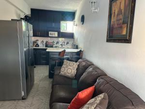 a living room with a couch and a kitchen at Remarkable 1-Bed Apartment in Montego Bay in Montego Bay