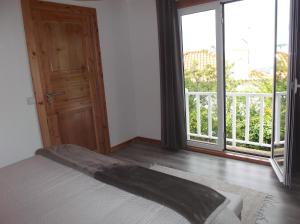 a bedroom with a bed and a large window at Casa do Morro in Sintra