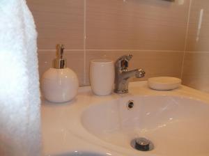 a sink with a faucet and two cups on it at Casa do Morro in Sintra