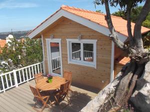 eine Holzhütte mit einem Tisch und Stühlen auf einer Terrasse in der Unterkunft Casa do Morro in Sintra