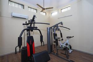 a gym with two treadmills and two exercise bikes at Capital O 7302 The Huespedes in Gurgaon
