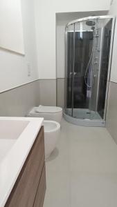uma casa de banho com um WC e uma cabina de duche em vidro. em Civico 5 em Bacu Abis