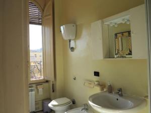 een badkamer met een wastafel, een toilet en een spiegel bij Skyline Formia in Formia