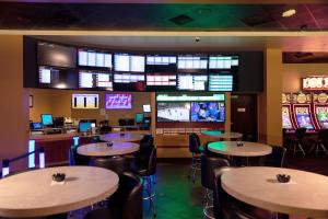 un restaurante con mesas, sillas y TV en Treasure Bay Casino & Hotel-Adults Age 21 and Above en Biloxi