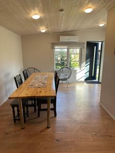 a dining room with a wooden table and chairs at Karjamaa Garden Bungalows in Pärnu