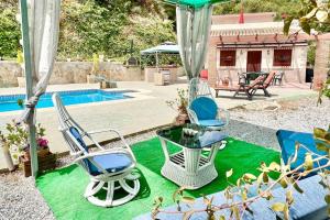 Tres sillas y una mesa junto a una piscina. en Villa private pool La Herradura, en La Herradura
