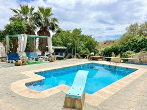 uma grande piscina com um banco ao lado em Villa private pool La Herradura em La Herradura