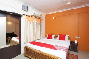 a bedroom with a large bed with red pillows at New Mega Palace in Bankipur