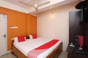 um quarto com uma cama grande e almofadas vermelhas em New Mega Palace em Bankipur