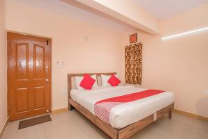 a bedroom with a bed with red pillows and a door at OYO 8116 Park Inn in Bangalore