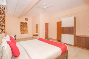 a bedroom with a large white bed with red pillows at OYO 8116 Park Inn in Bangalore