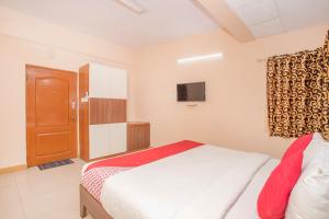 a bedroom with a bed and a television in it at OYO 8116 Park Inn in Bangalore
