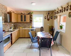 a kitchen with a table and chairs and a table and a kitchen at Vivien vendégház 1 in Ordacsehi