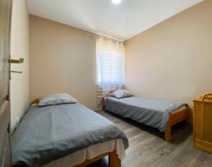 a bedroom with two beds and a window at Vivien vendégház 1 in Ordacsehi